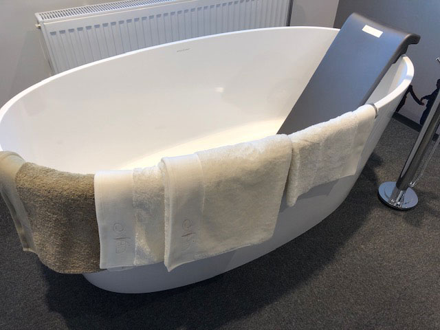 Ovalt badekar utstilt med håndklær over badekarkanten i butikken til Zetlitz i Tønsberg.